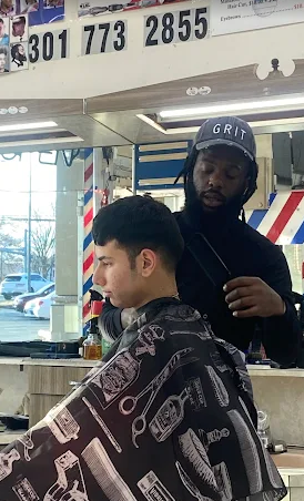 Barber at Dodge Park Barbershop cutting a client's hair in the shop