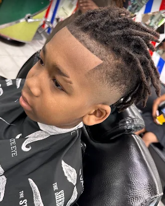 Young client with locs and a clean taper fade