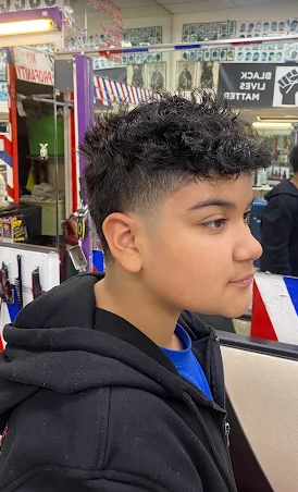 Textured curly top with a clean mid fade
